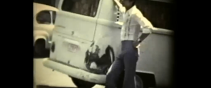 Beeld uit een film van een man die bij een volkswagenbusje staat