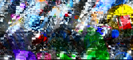 Detailfoto van een hoop plastic flesjes en blikjes
