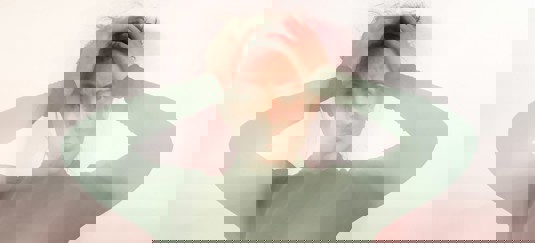 Een vrouw die haar hoofd vasthoudt van frustratie en vertwijfeling