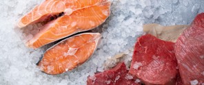 Vers gesneden zalm en stukjes rood vlees liggen op een bed van ijs.